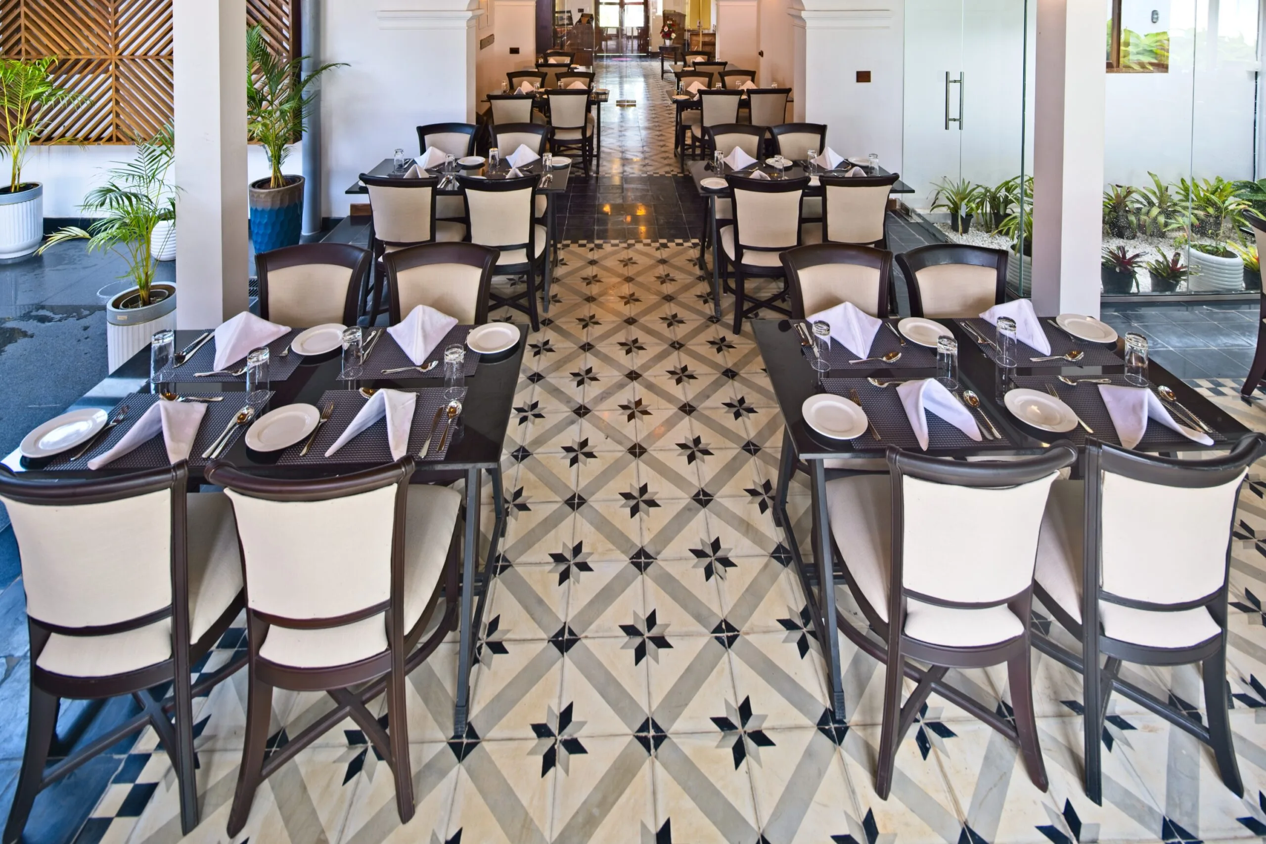 Set tables either side of a black and cream star-patterned tile floor.